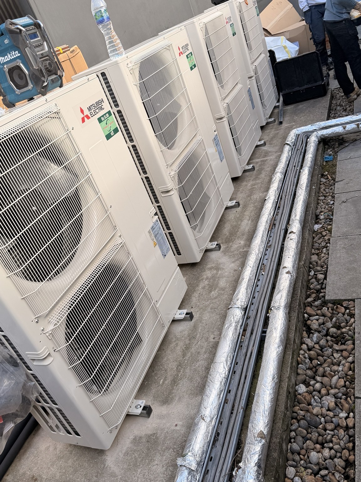 Bank of Mitsubishi VRF outdoor condensing units on a commercial roof